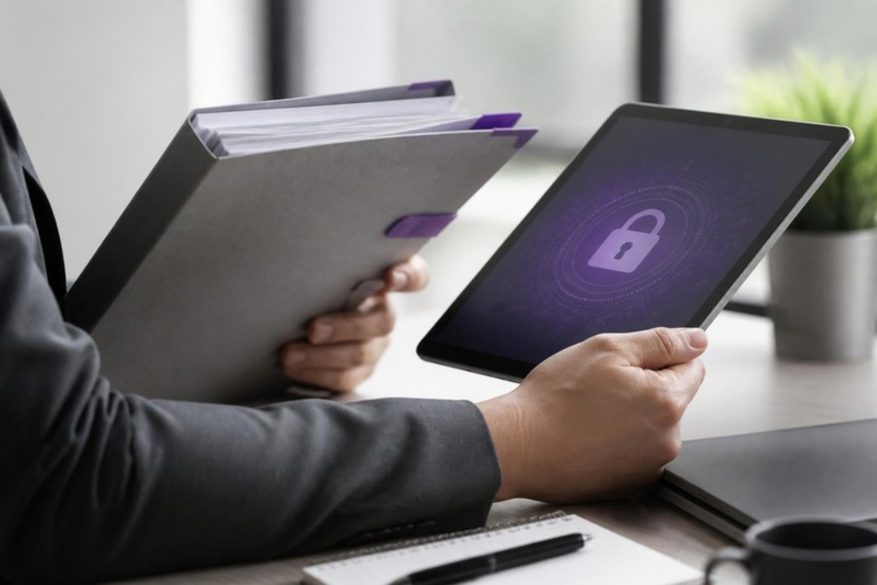 Manos sosteniendo una carpeta de documentos y una tablet con un candado de seguridad